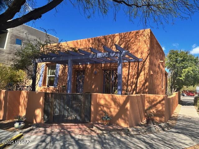 exterior space with a fenced front yard, a gate, and a pergola