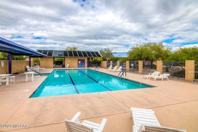 pool featuring fence and a patio