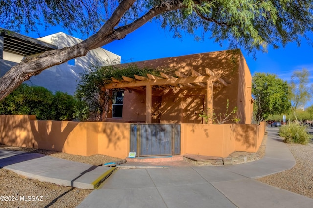 exterior space with a gate, fence, and a pergola