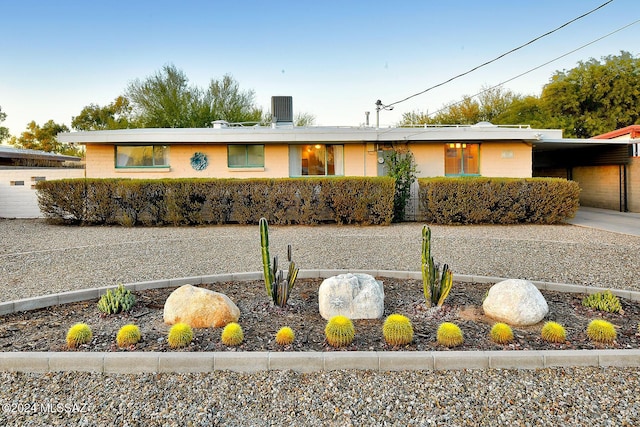 ranch-style house with a carport, a garage, and central AC