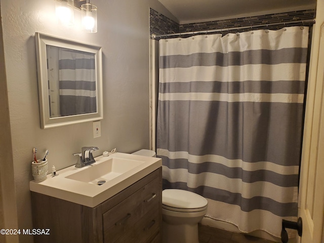 bathroom featuring vanity, toilet, and curtained shower
