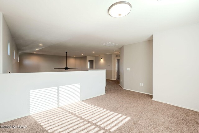 empty room with ceiling fan and light carpet