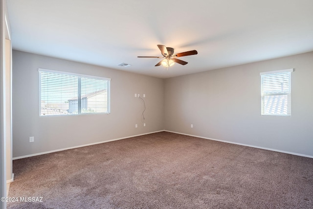 carpeted empty room with a wealth of natural light and ceiling fan