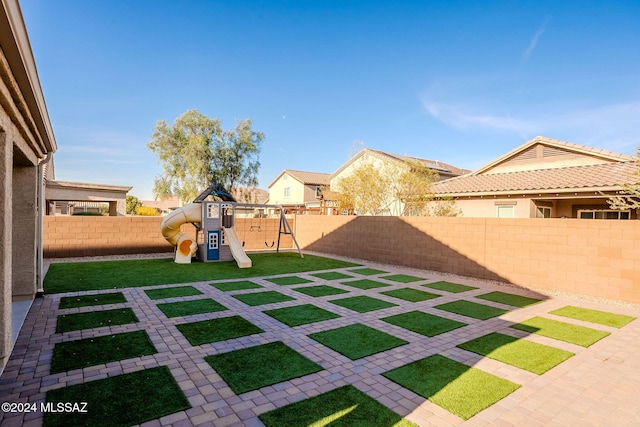 view of yard featuring a playground and a patio