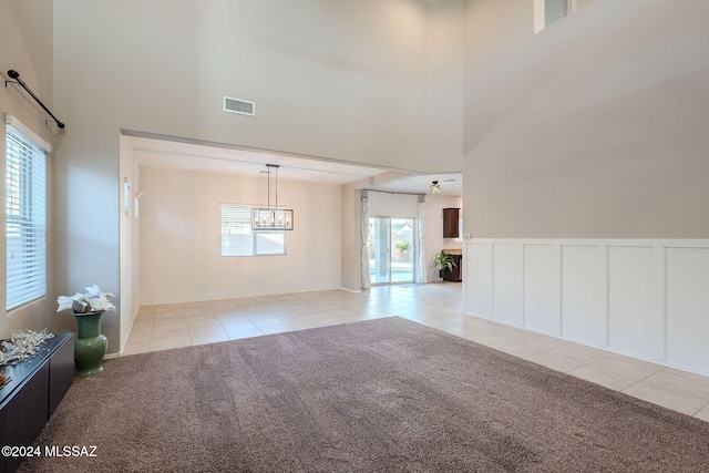 empty room with light colored carpet and a towering ceiling