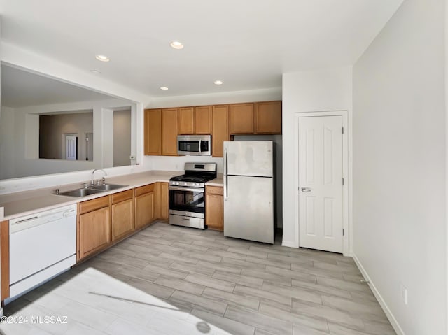 kitchen with sink, light wood-type flooring, and appliances with stainless steel finishes