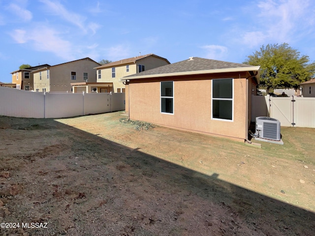 rear view of property with a yard and central AC