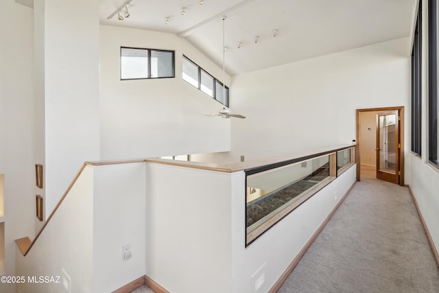 hall with lofted ceiling and light carpet