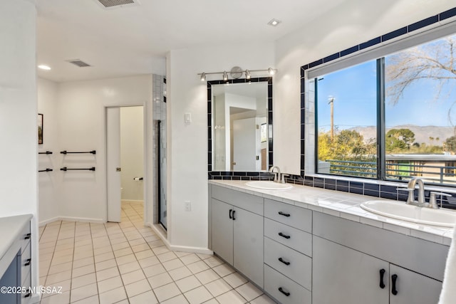 bathroom featuring tile patterned floors, vanity, an enclosed shower, and a mountain view