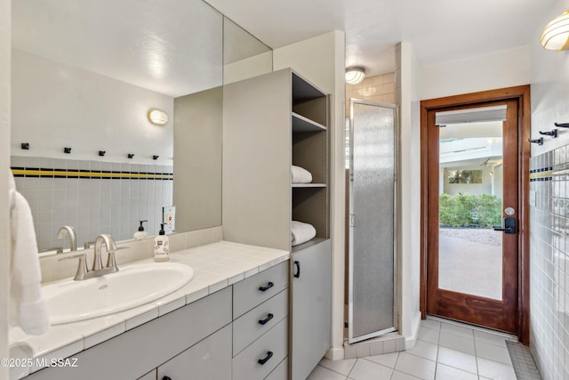 bathroom with vanity, a shower with shower door, and tile patterned floors