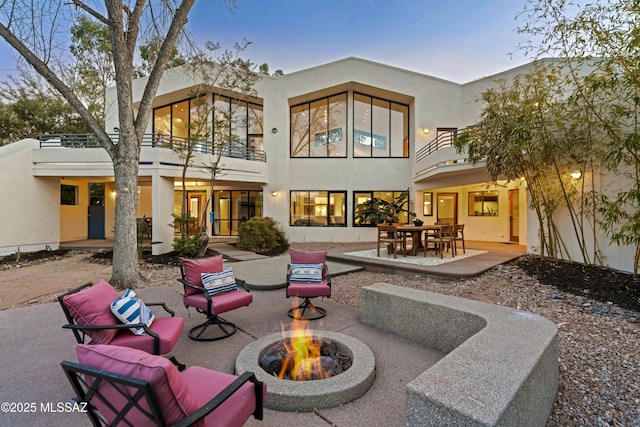 back house at dusk with a patio and a fire pit