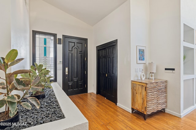 foyer entrance featuring hardwood / wood-style floors and vaulted ceiling