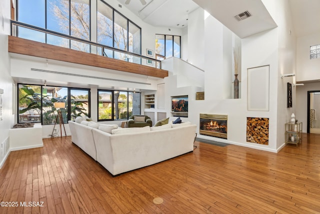 living room with a high ceiling and wood-type flooring