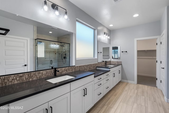 bathroom with tasteful backsplash, vanity, and an enclosed shower