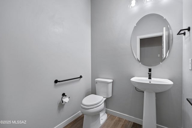 bathroom featuring hardwood / wood-style flooring and toilet