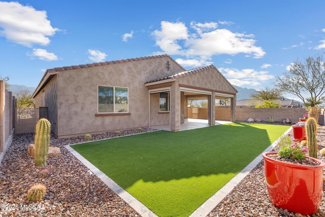 rear view of house featuring a patio and a lawn