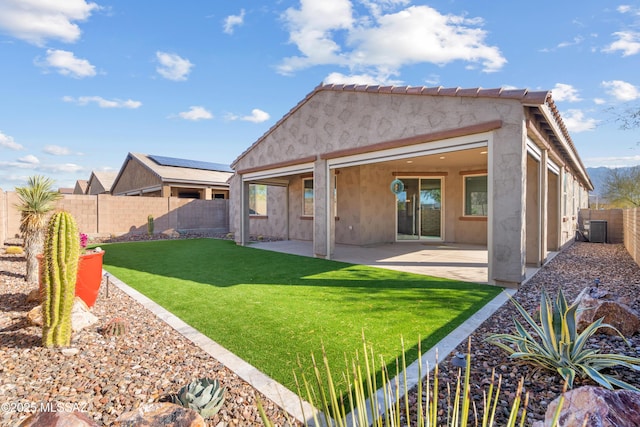 back of property featuring a yard, cooling unit, and a patio area