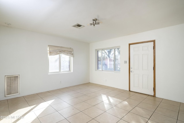 spare room featuring a wealth of natural light and light tile patterned floors