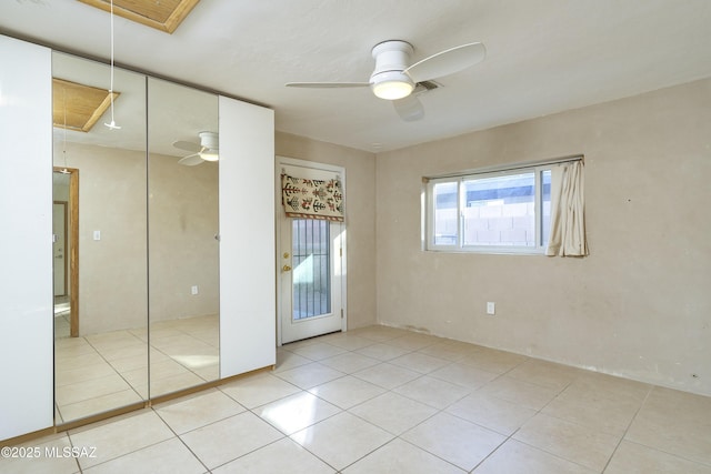 tiled empty room featuring ceiling fan