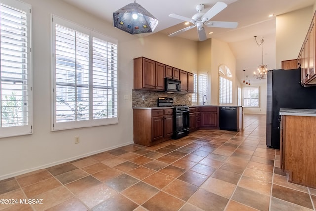 kitchen featuring backsplash, a healthy amount of sunlight, black appliances, and decorative light fixtures