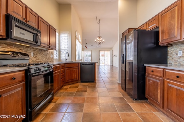 kitchen featuring backsplash, black appliances, pendant lighting, high vaulted ceiling, and a notable chandelier