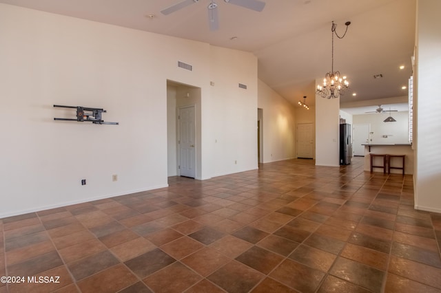 spare room with high vaulted ceiling and ceiling fan with notable chandelier