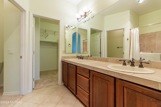 bathroom featuring tile patterned flooring, vanity, and a bath