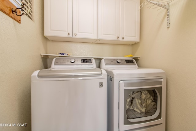 washroom featuring cabinets and separate washer and dryer