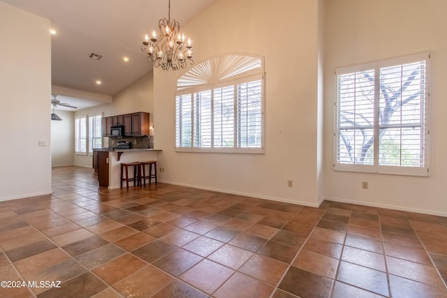 interior space with high vaulted ceiling, a healthy amount of sunlight, and ceiling fan with notable chandelier