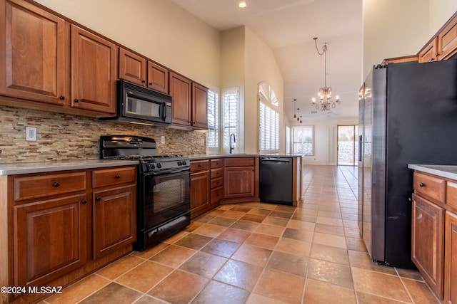 kitchen featuring backsplash, sink, black appliances, pendant lighting, and an inviting chandelier