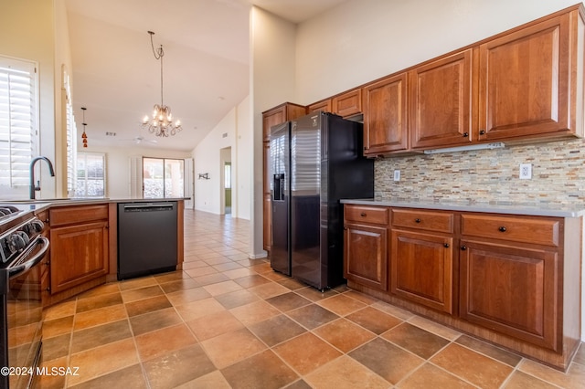 kitchen featuring stove, decorative light fixtures, an inviting chandelier, dishwasher, and stainless steel fridge with ice dispenser