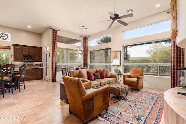 living room featuring light tile patterned floors and ceiling fan with notable chandelier