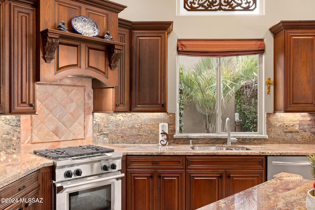 kitchen with decorative backsplash, appliances with stainless steel finishes, light stone counters, and sink