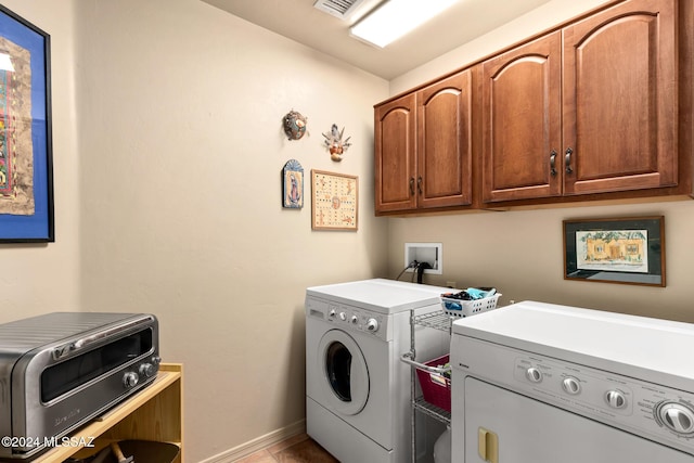 laundry room with cabinets, washing machine and dryer, and light tile patterned flooring