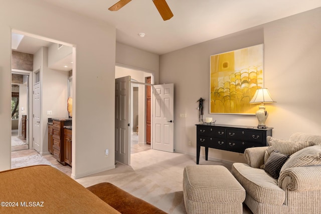 living area with light carpet and ceiling fan