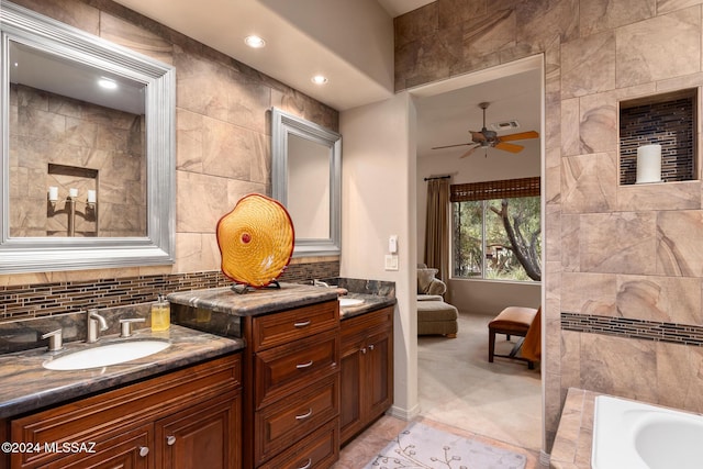 bathroom with vanity, ceiling fan, and a bathing tub