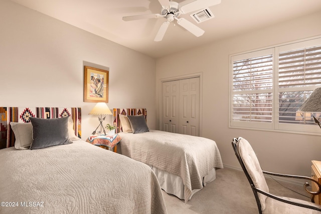 carpeted bedroom featuring ceiling fan and a closet