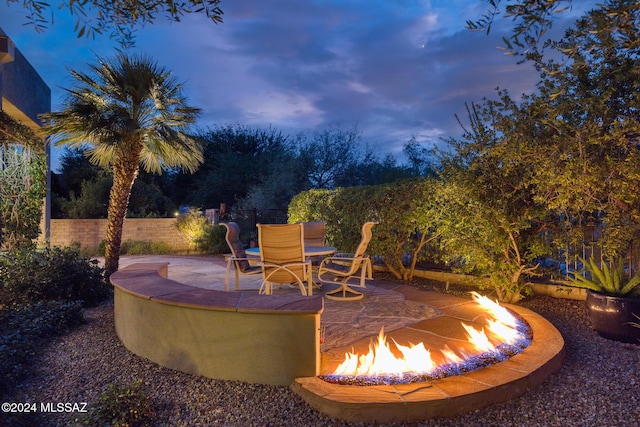 patio terrace at dusk featuring an outdoor fire pit