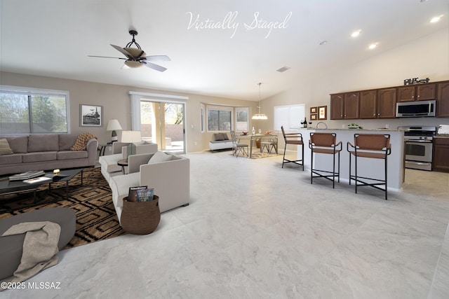 living room with ceiling fan with notable chandelier and lofted ceiling