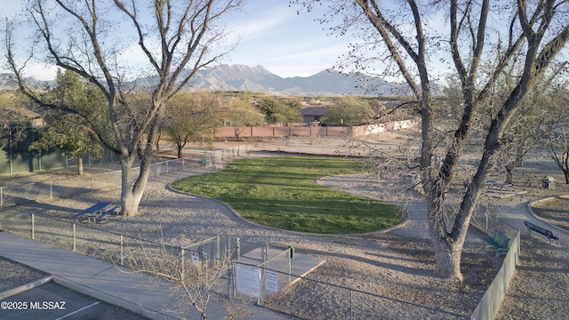 surrounding community with a mountain view and a yard