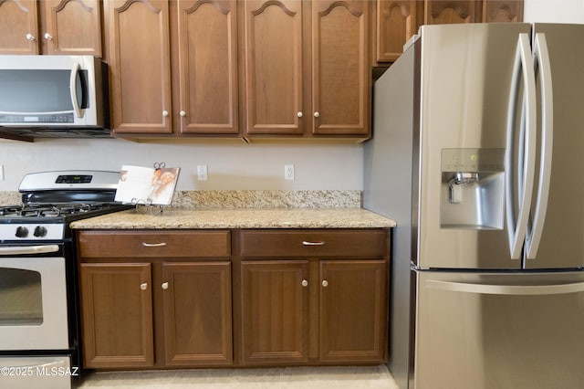 kitchen featuring white gas stove and stainless steel fridge