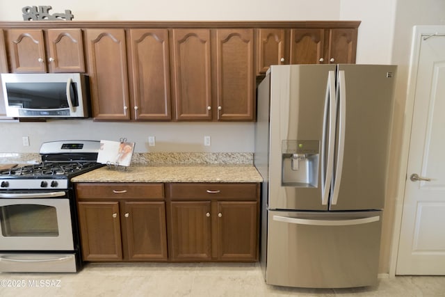 kitchen with gas range gas stove and stainless steel refrigerator with ice dispenser