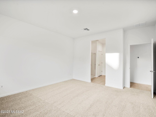 unfurnished bedroom featuring visible vents, light colored carpet, and baseboards