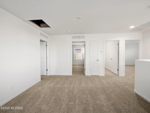 spare room featuring baseboards, visible vents, and carpet flooring
