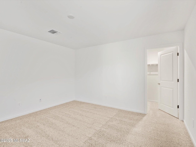 spare room featuring carpet flooring, visible vents, and baseboards