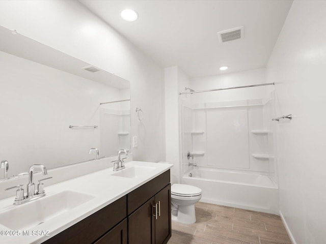 full bathroom with visible vents, wood finished floors, toilet, and a sink