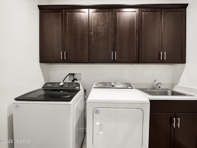 laundry area with cabinet space, washer and clothes dryer, and a sink