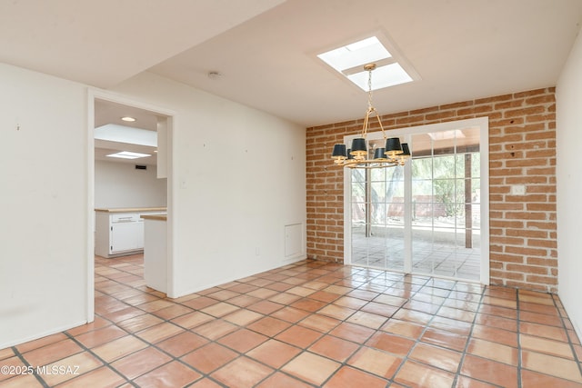 empty room with light tile patterned flooring, brick wall, a skylight, and a notable chandelier