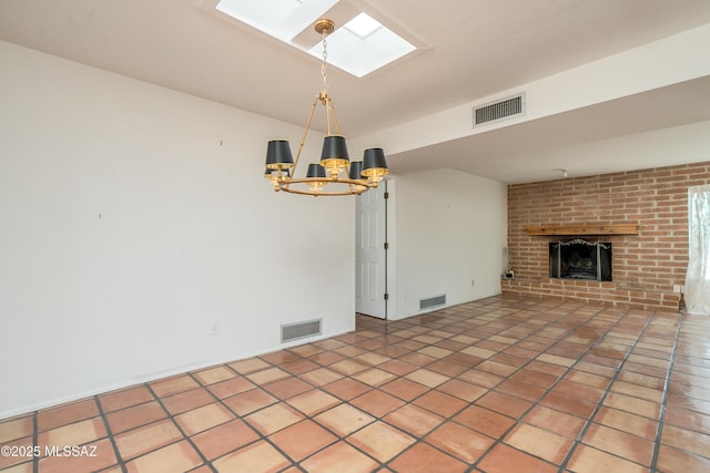 unfurnished living room featuring a fireplace, a skylight, tile patterned floors, and a chandelier