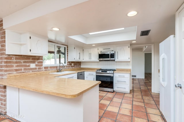 kitchen featuring white cabinetry, stainless steel appliances, kitchen peninsula, and sink